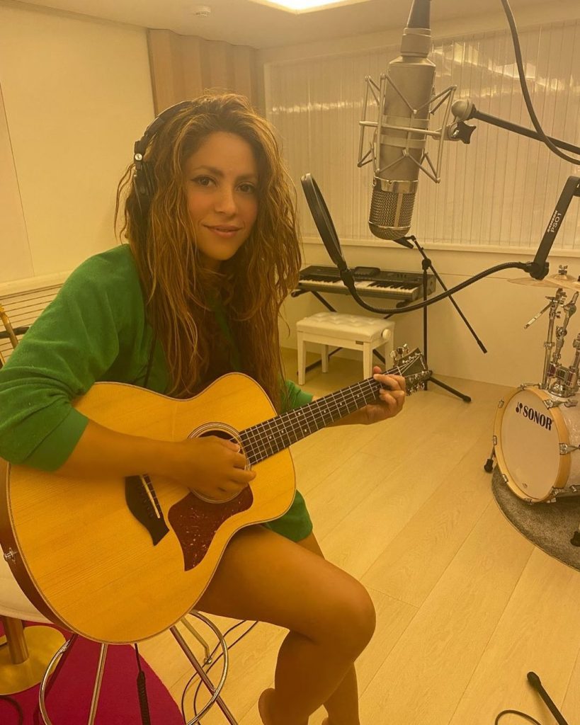 Shakira is in the studio with a guitar